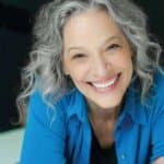 a grey-haired beautiful woman smiling at the camera