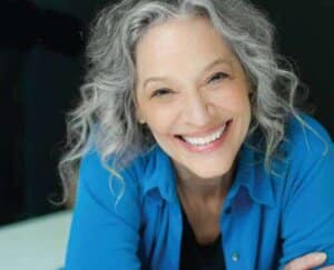 a grey-haired beautiful woman smiling at the camera