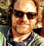 a man wearing sunglasses and a neck scarf