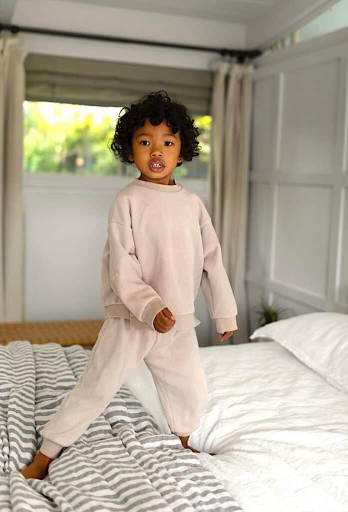 Child standing on a bed.