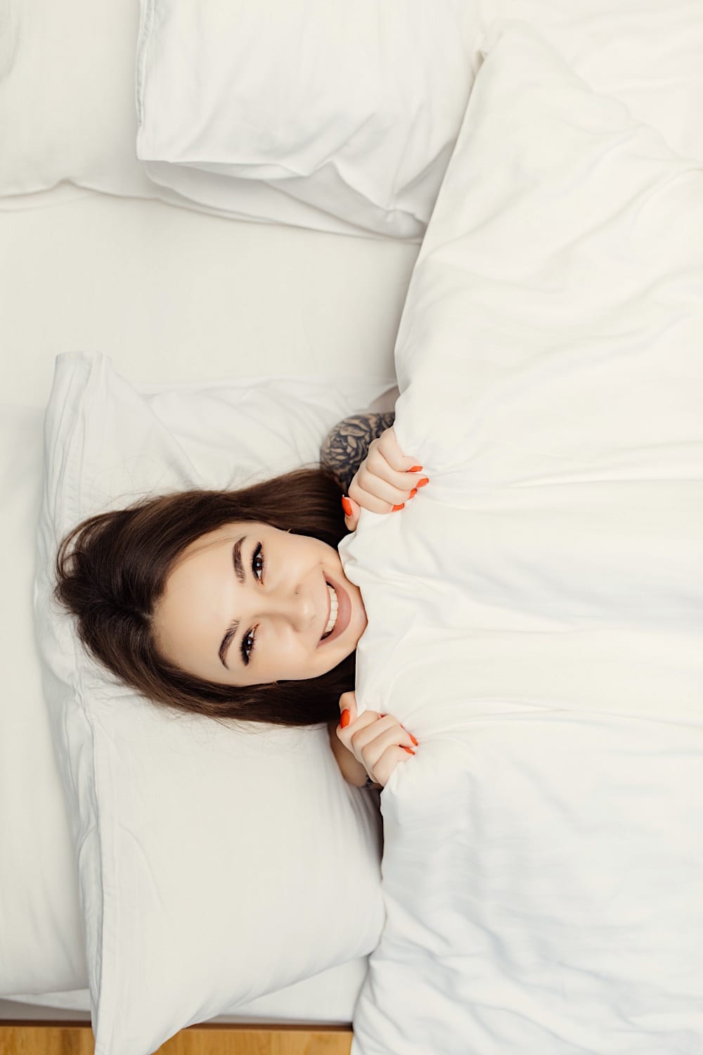 a woman lying in bed smiling