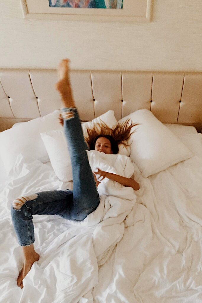 a woman lying on a bed with her leg up