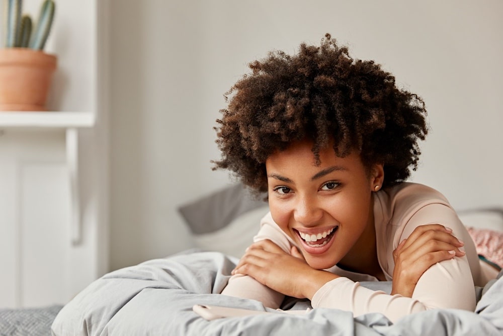 Person relaxing on a cozy bed.