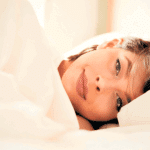 Person resting on a bed.